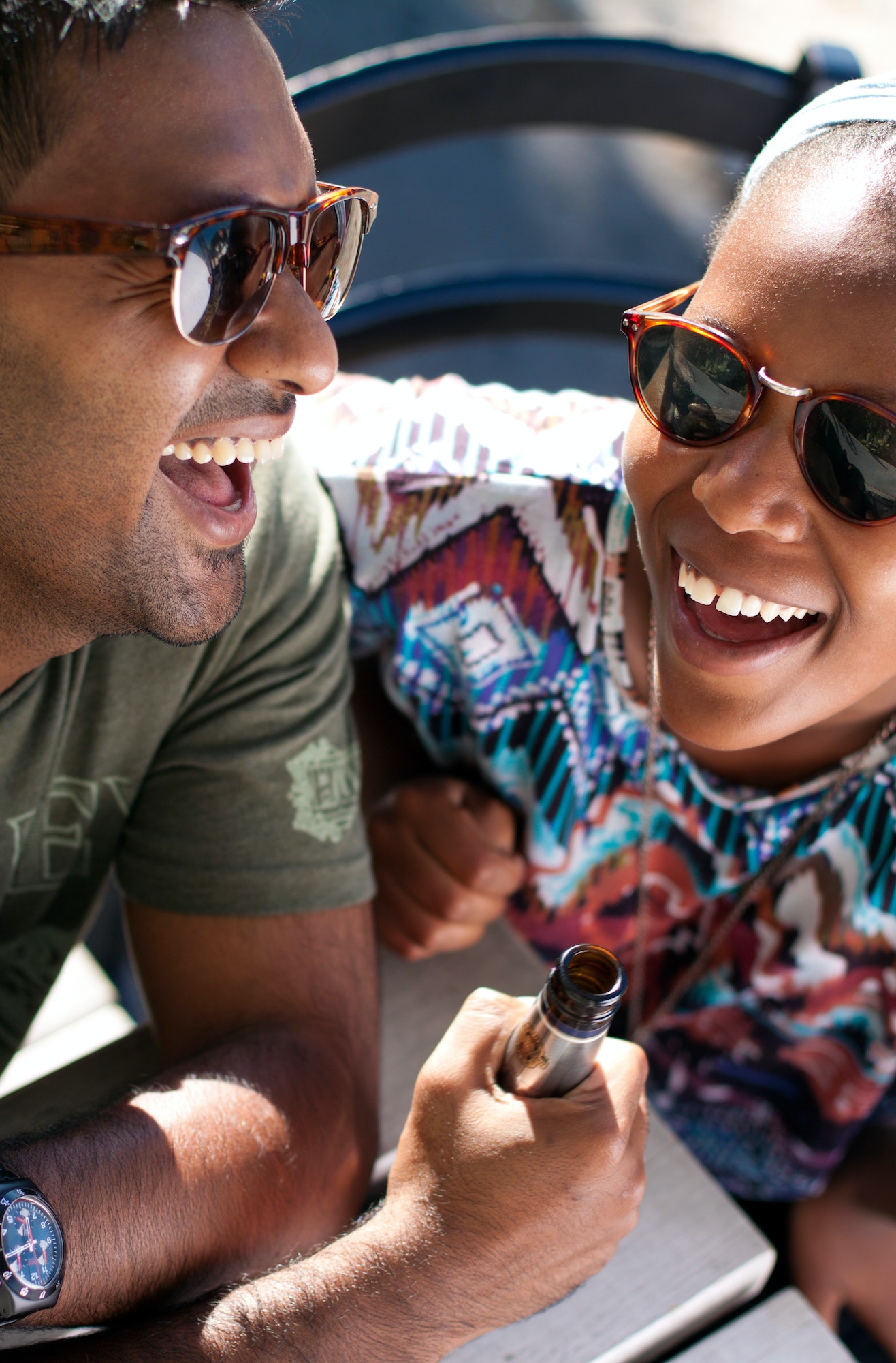 Two friends enjoying a beer, laughing and having a good time