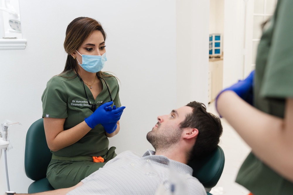 Dr Aunce Abduallah Doctor In Houston Texas With Patient Talking About Dental Treamtent