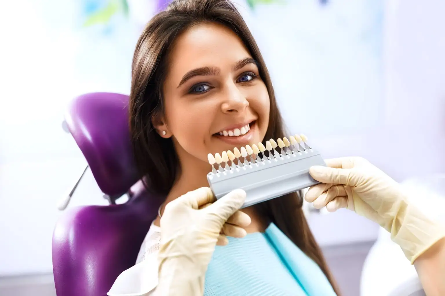 Cosmetics And Veneers Doctor Holding Teeth Cosmetics for Patient Smiling Picking Best Grade of light for teeth.